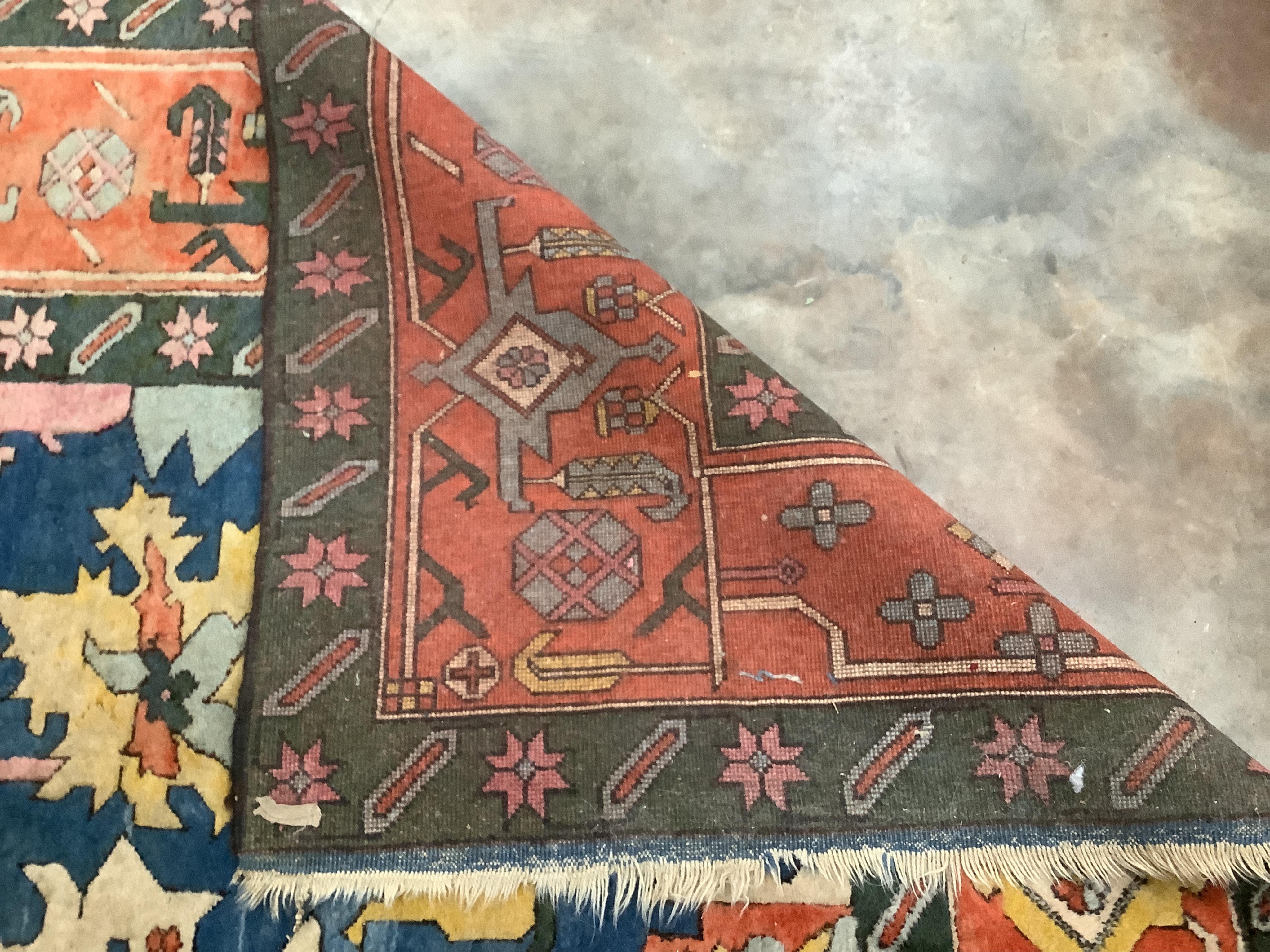 A Caucasian style polychrome carpet, with a blue field and red geometric border, 390 x 236cm. Condition - fair